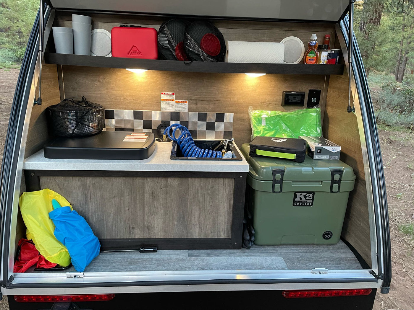and ceiling fan/vent.|RV rental bedroom: bed with overhead storage — photo 8