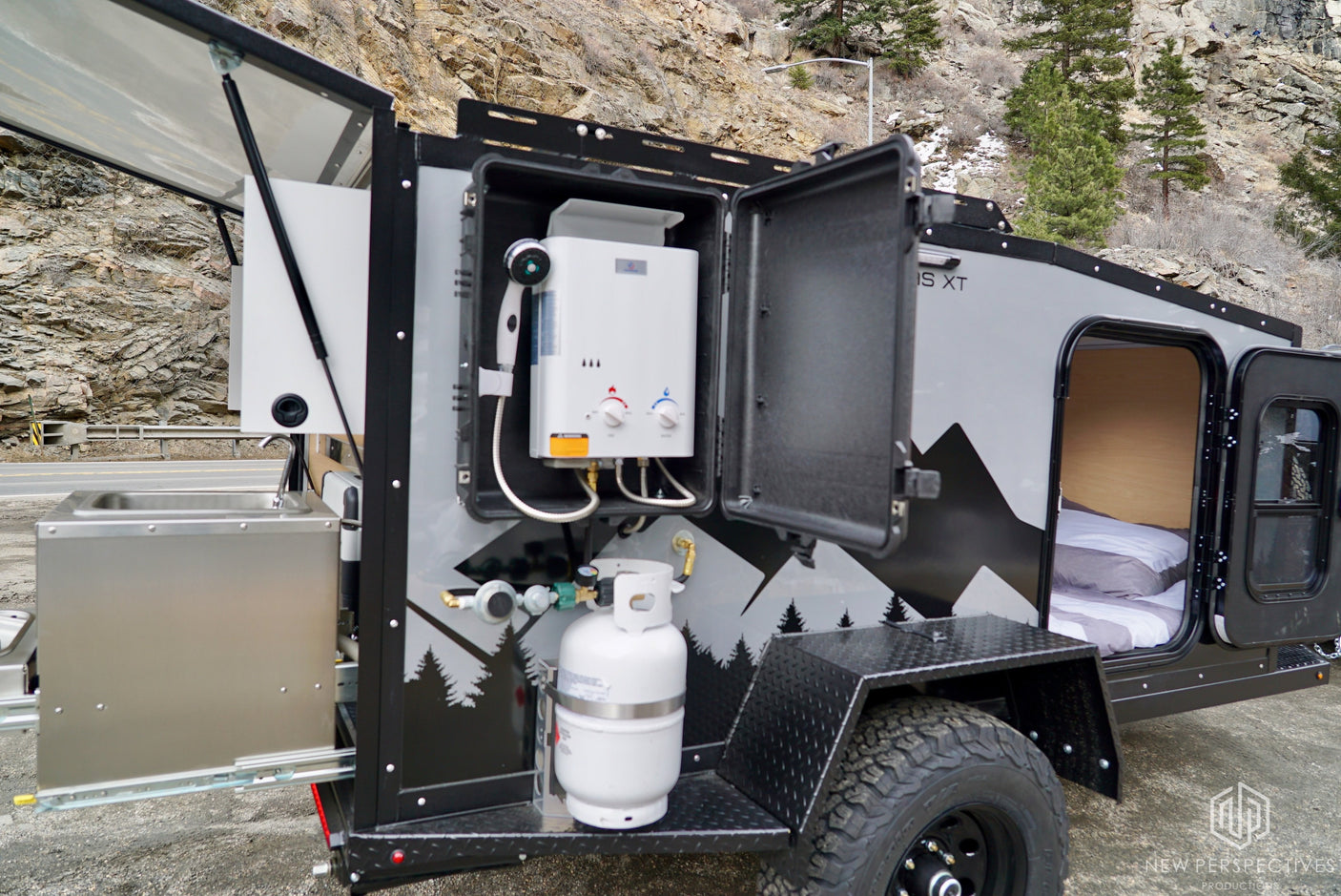 Compact RV rental camper with outdoor hot shower, pull-out kitchen, and cozy bed. Ideal for off-grid adventures.