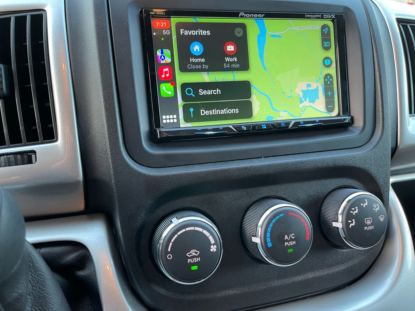 RV rental dashboard: Pioneer display with Apple CarPlay navigation (Maps favorites), plus tactile climate control knobs.