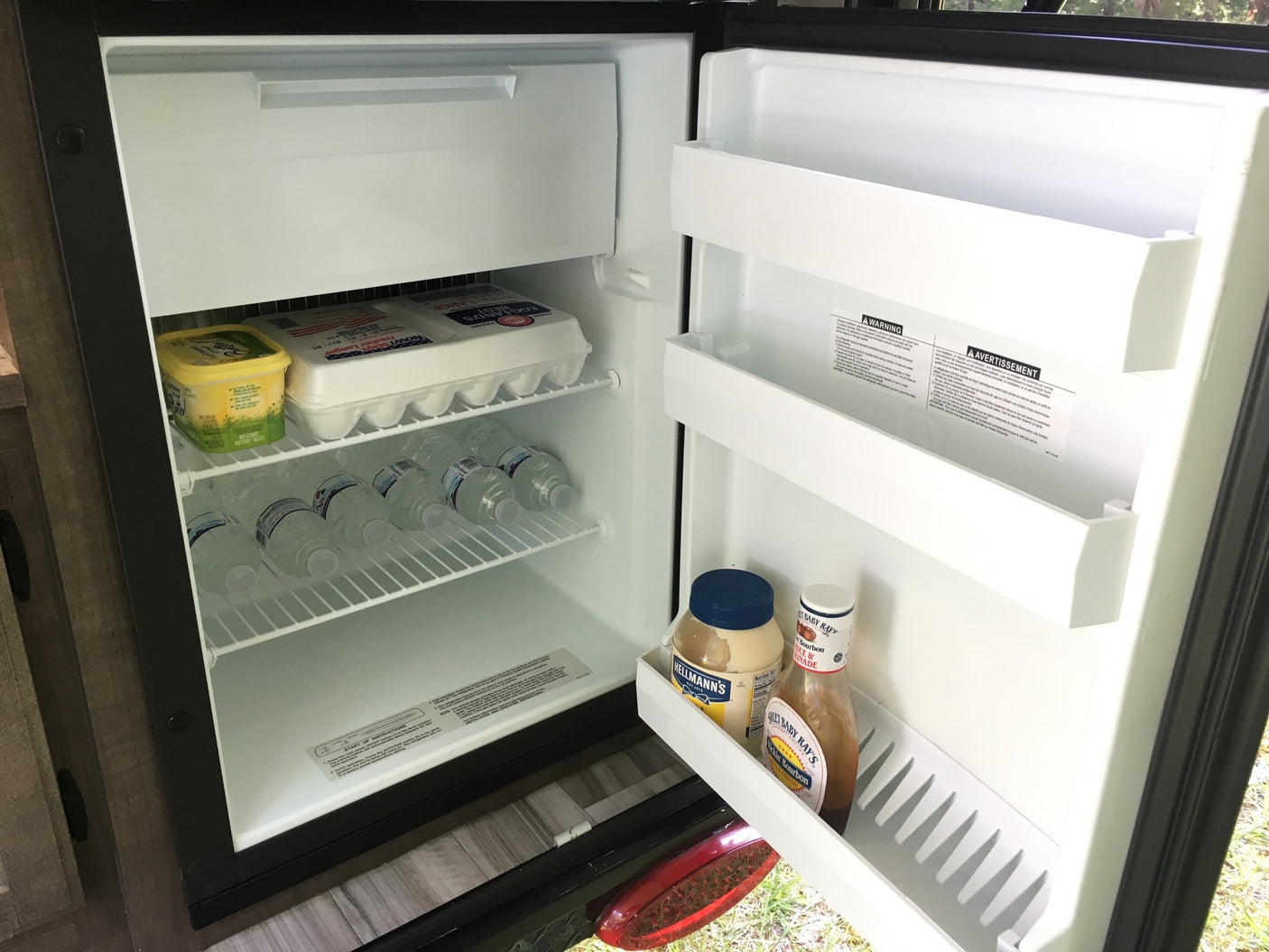 Stocked mini-fridge in an RV rental, packed with eggs, water, and essentials for your travels.