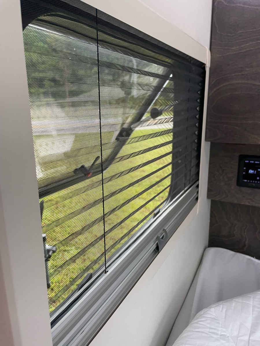 and microwave.|A white teardrop RV rental is set up for camping