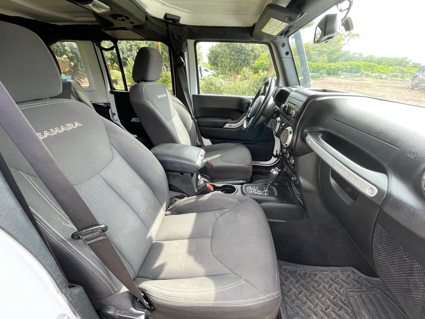View inside a Jeep Wrangler Sahara. Note the 'SINCE 1941' handle. An agile choice for your adventure, different from a typical RV rental.