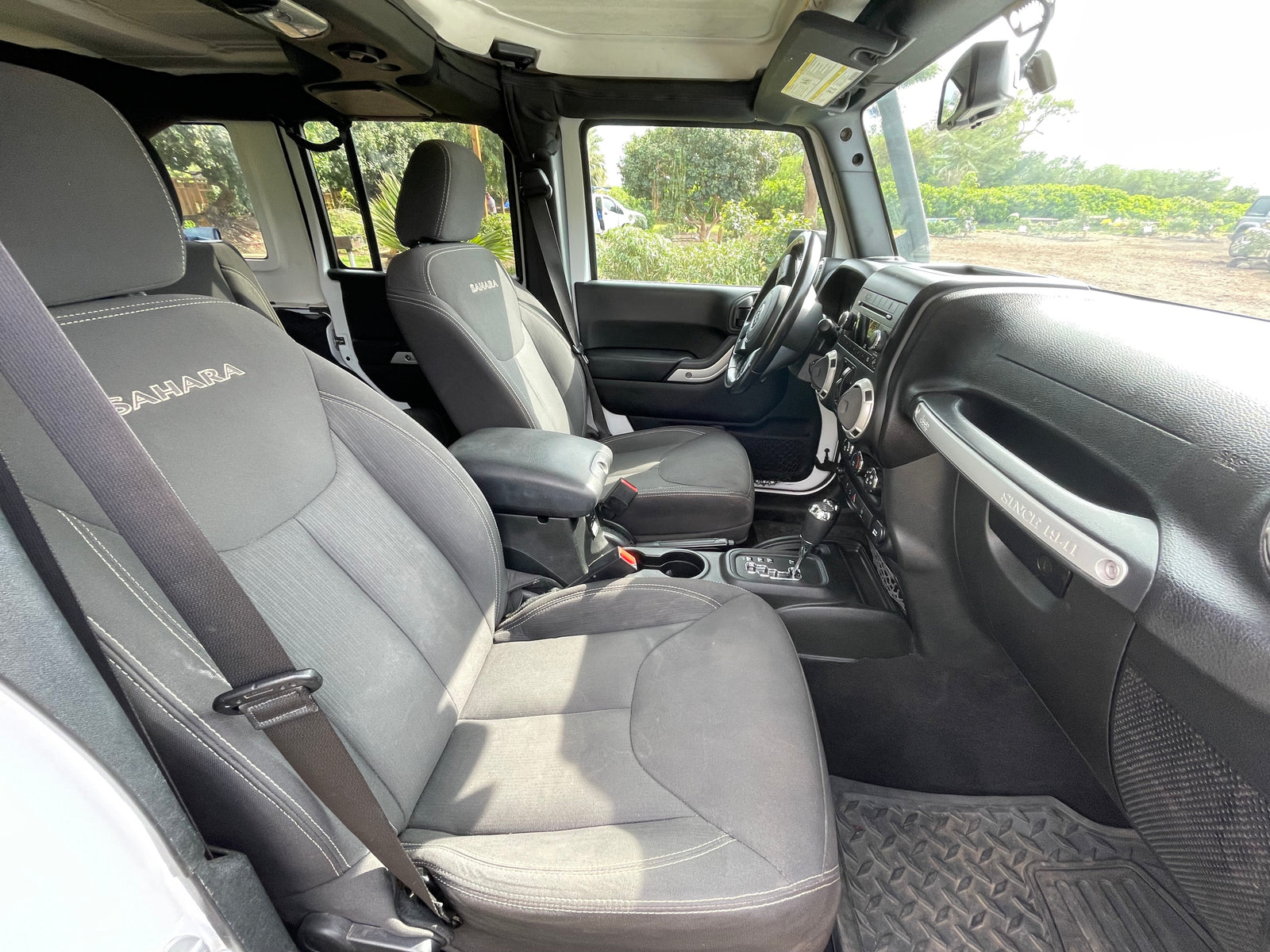 View inside a Jeep Wrangler Sahara. Note the 'SINCE 1941' handle. An agile choice for your adventure, different from a typical RV rental.