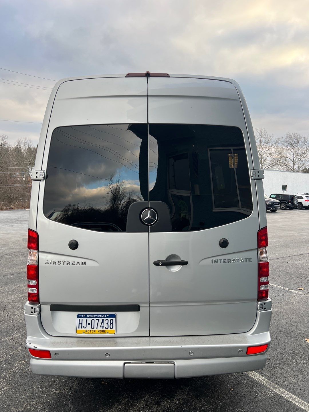 Silver Airstream Interstate RV rental van (Mercedes-Benz Sprinter) from rear. PA 'MOTOR HOME' plate visible.