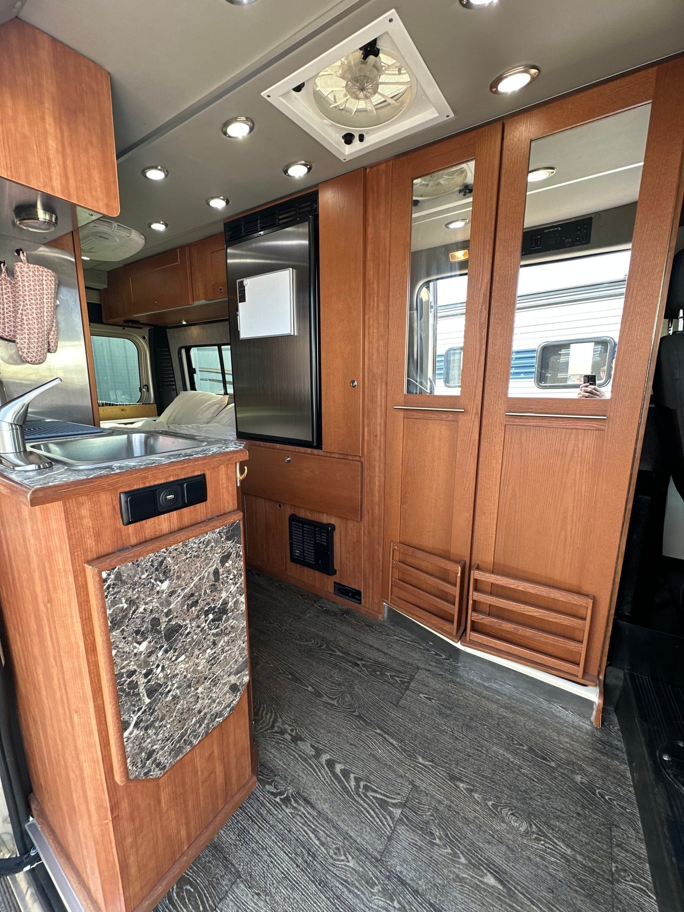 and adjacent cozy sleeping area. Perfect for mobile adventures.|Cozy RV rental bedroom with comfortable bed
