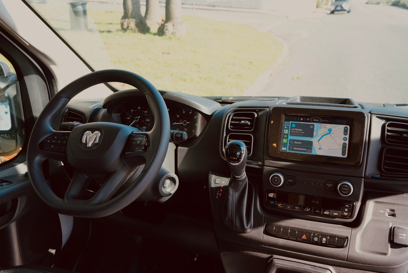 RV rental: Driver's view of a modern dashboard, Ram steering wheel, and navigation screen, ready for a road trip.