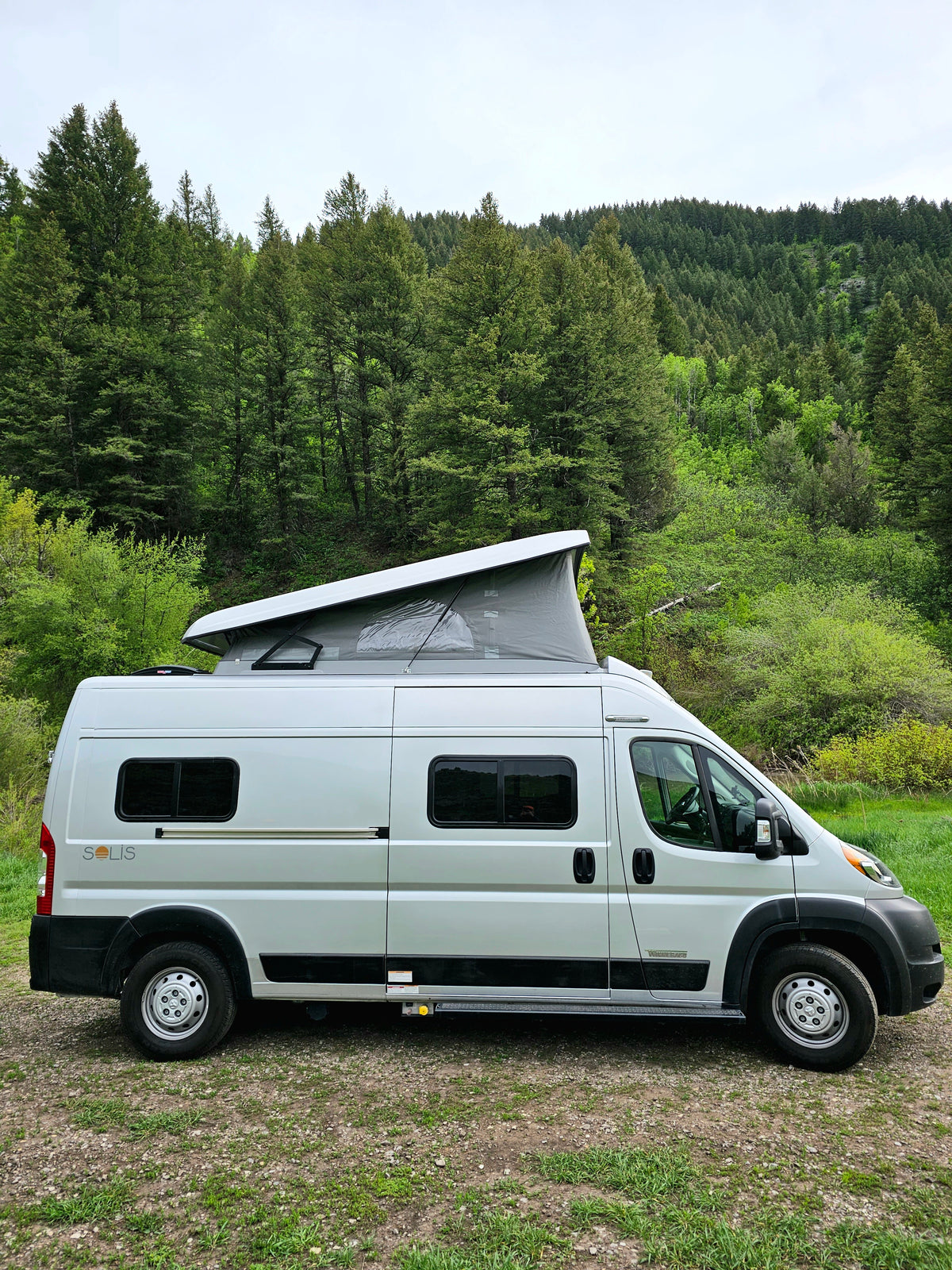 surrounded by a lush green forest.|This Winnebago Solis rv rental — photo 2