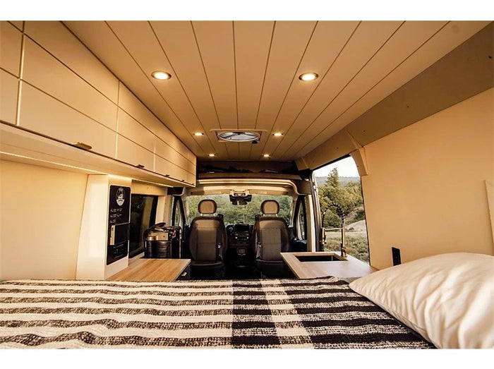 RV rental interior: A cozy camper van features a bed, kitchenette, and driver's cabin, perfect for travel adventures.