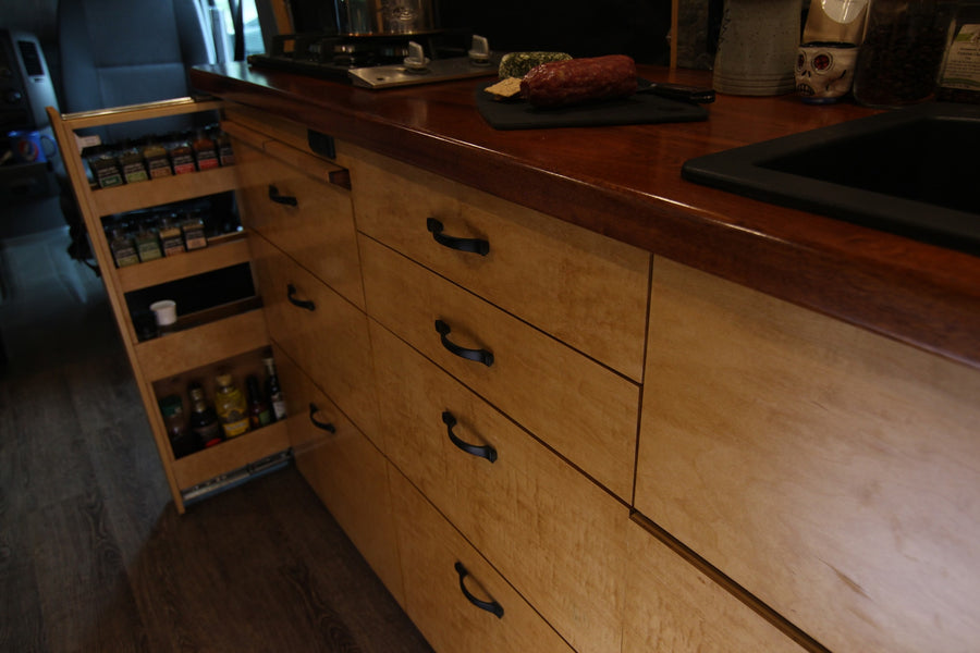 Smart storage in an RV rental: Pull-out spice rack and multiple wood drawers maximize compact kitchen space.