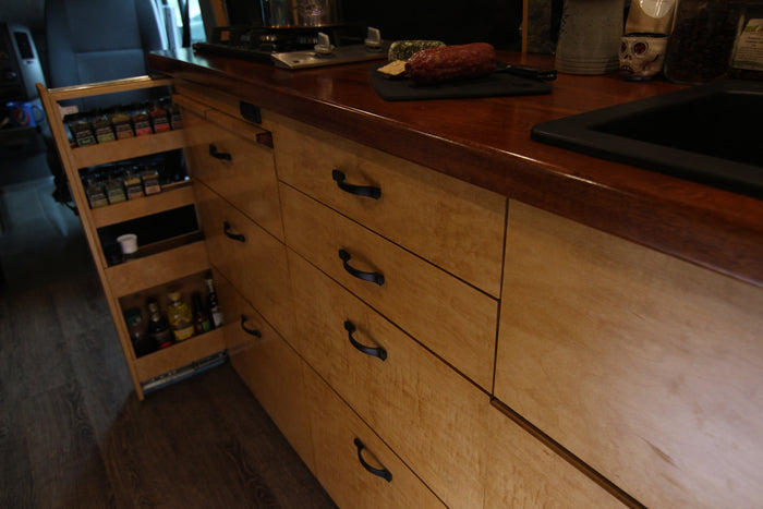 Smart storage in an RV rental: Pull-out spice rack and multiple wood drawers maximize compact kitchen space.