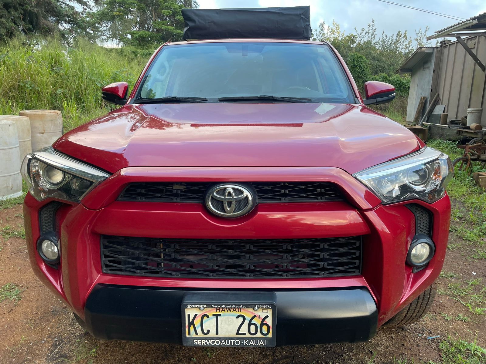 Front view: Red Toyota SUV with roof cargo bag, Hawaii plate KCT 266. Great for an rv rental road trip.