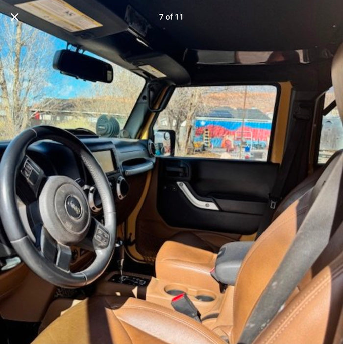 enjoying an off-road adventure at sunset.|View of a Jeep's brown leather interior