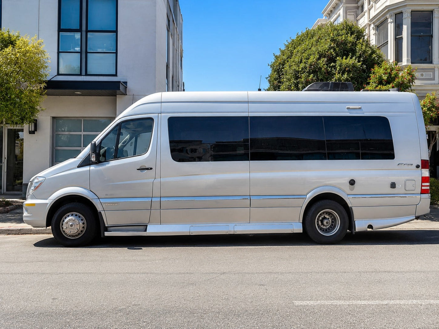Silver Mercedes-Benz Sprinter RV rental van parked on a sunny city street.|Silver Mercedes-Benz Sprinter RV rental — photo 1