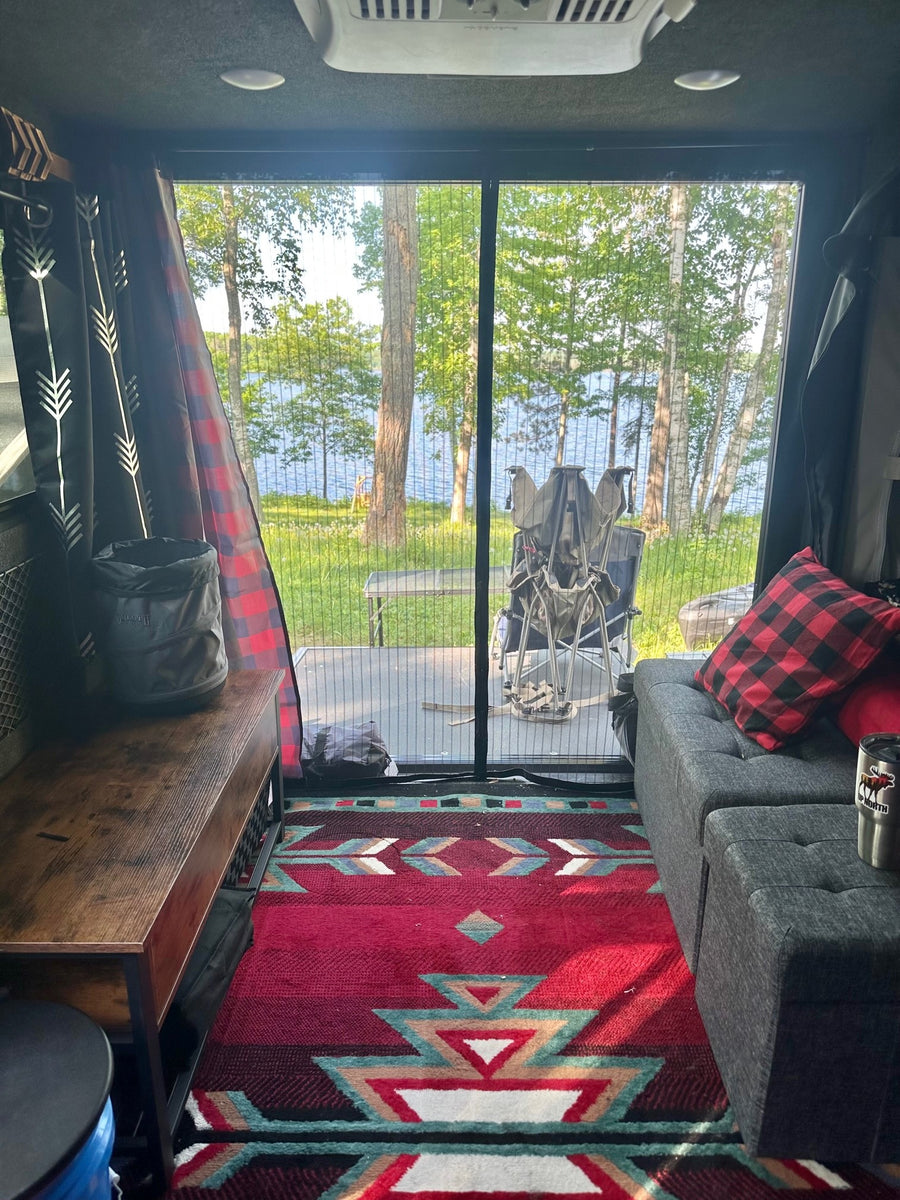 set up for camping in a wooded outdoor site.|Grey Flyer travel trailer