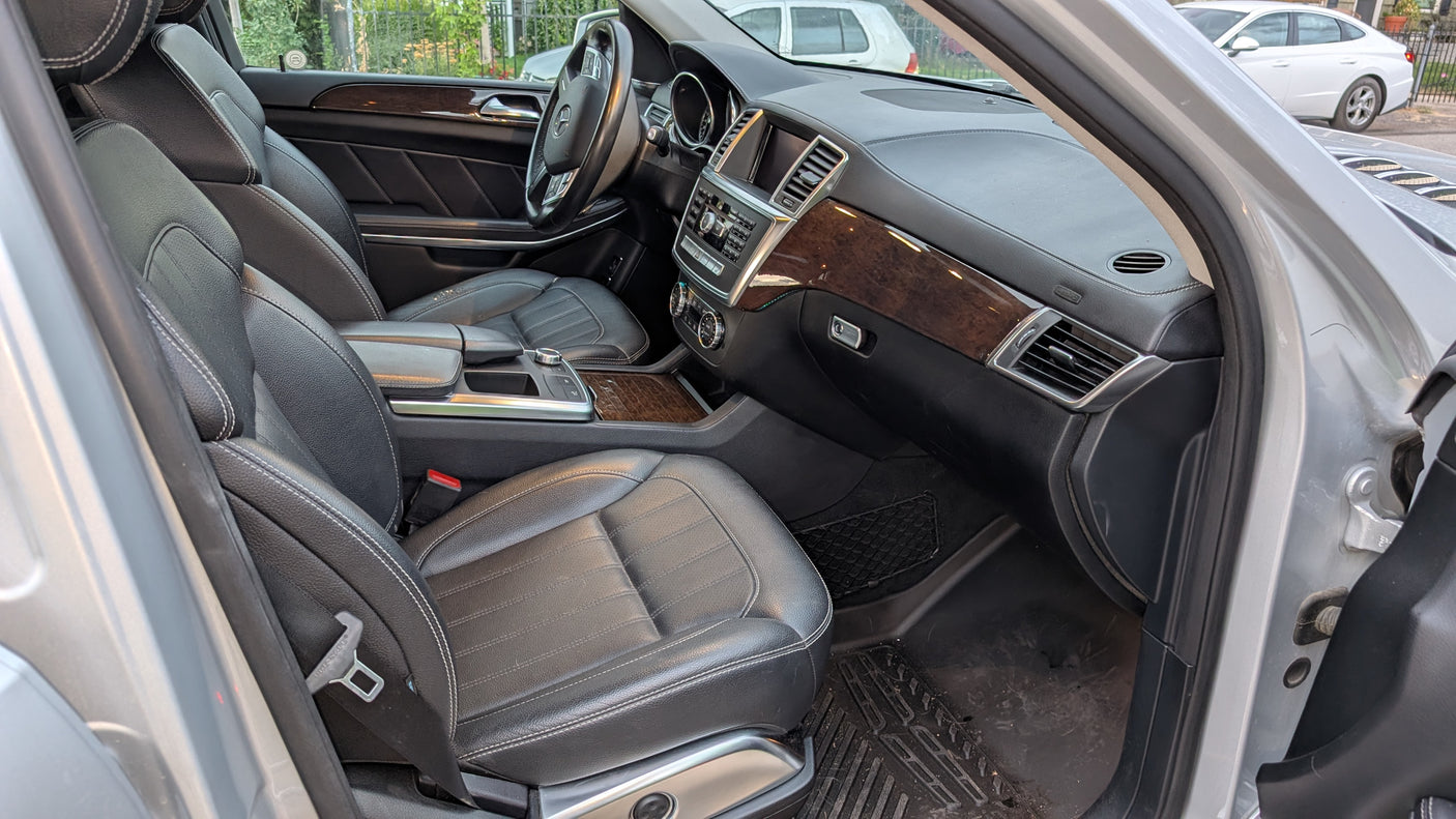 Inside a modern car: premium black leather seats, wood trim, and detailed dashboard. A comfortable option beyond typical RV rental.