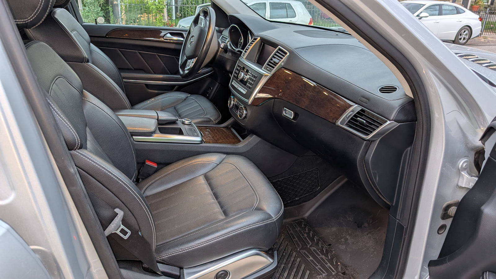 Inside a modern car: premium black leather seats, wood trim, and detailed dashboard. A comfortable option beyond typical RV rental.