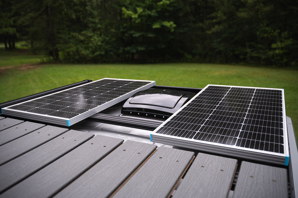 RV rental rooftop with two solar panels and a central vent, providing off-grid power.