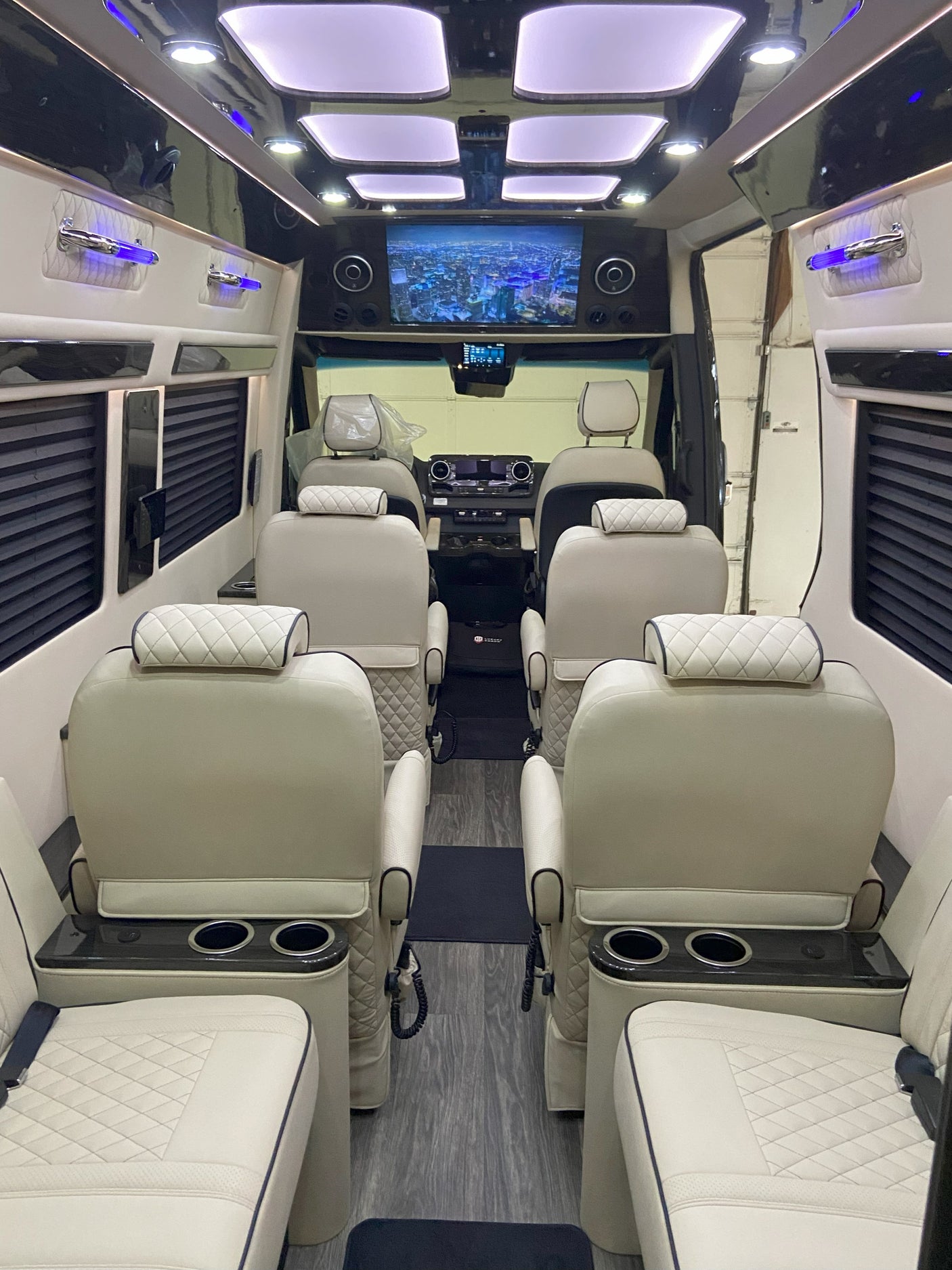 Luxury RV rental interior with spacious seating, entertainment screen, and ambient lighting for comfortable travel.