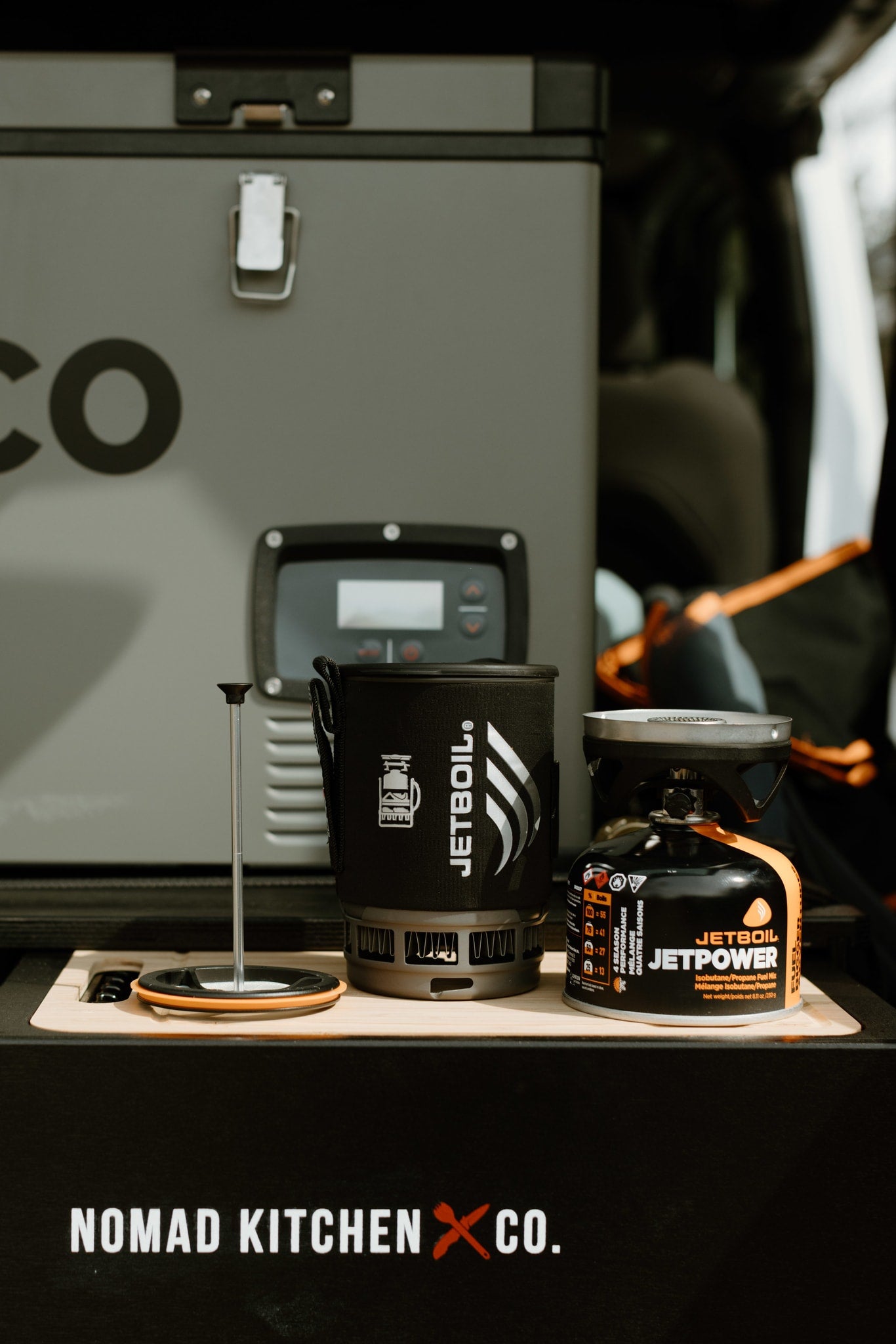 Outdoor cooking essentials: JetBoil system & portable fridge by Nomad Kitchen Co., great for an RV rental.