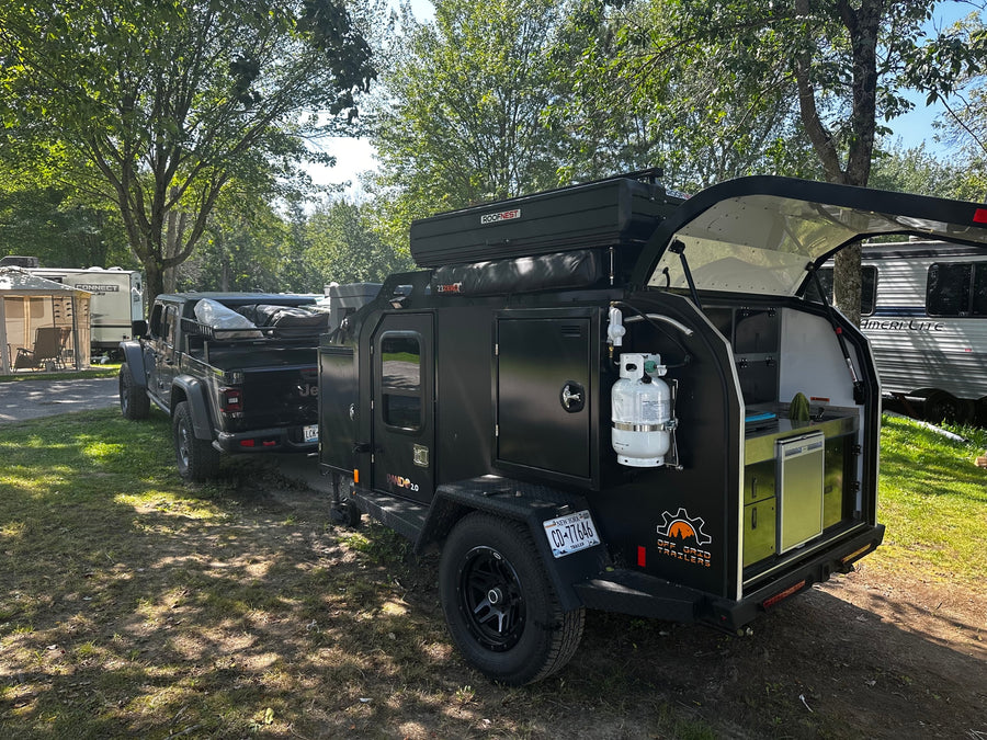 Explore off-grid with this RV rental: a black Pando 2.0 trailer with a Roofnest tent & outdoor kitchen