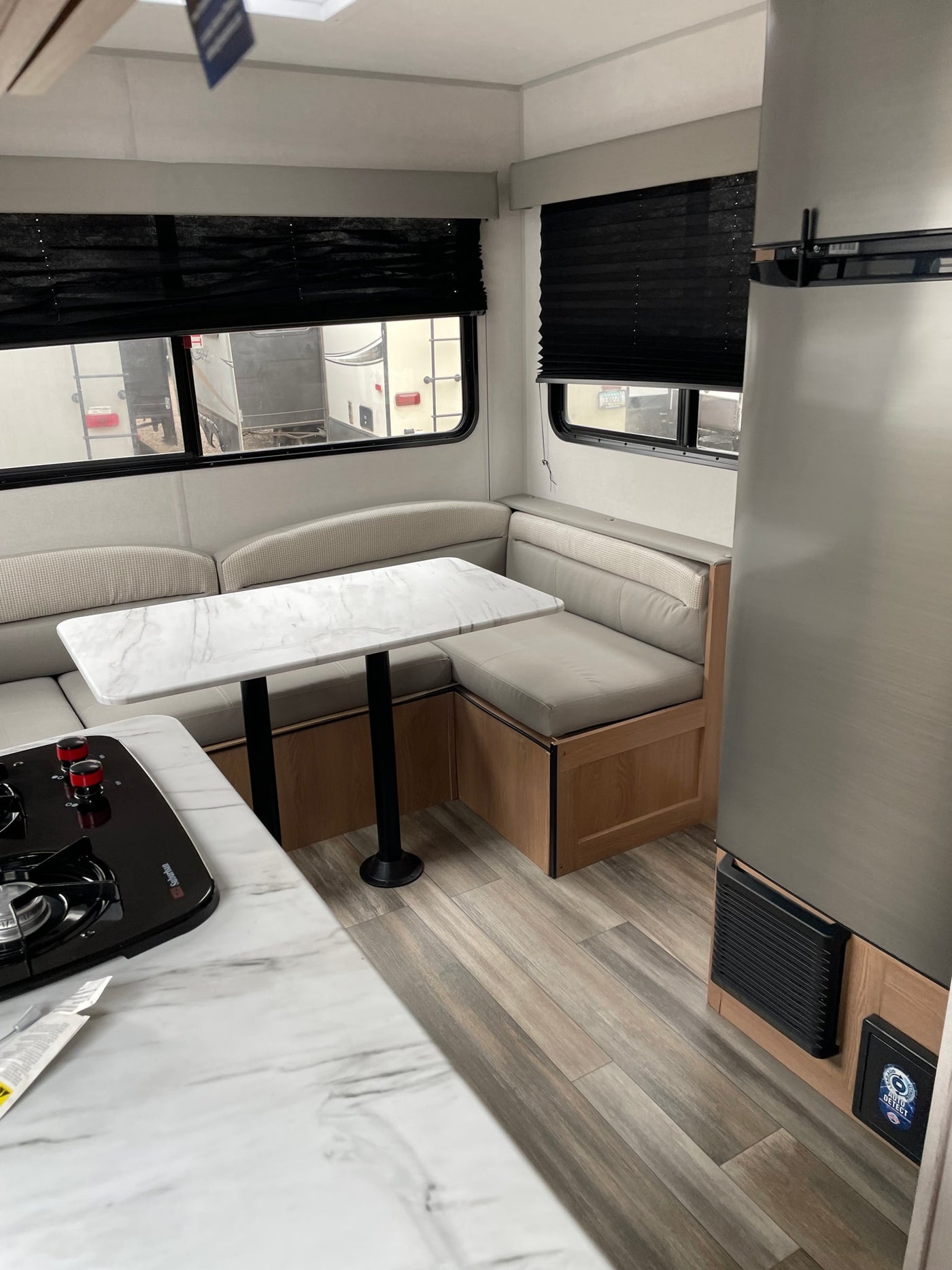 RV rental: A well-lit interior showcasing a U-shaped dinette, marble-patterned table, kitchen area, and fridge. — photo 1