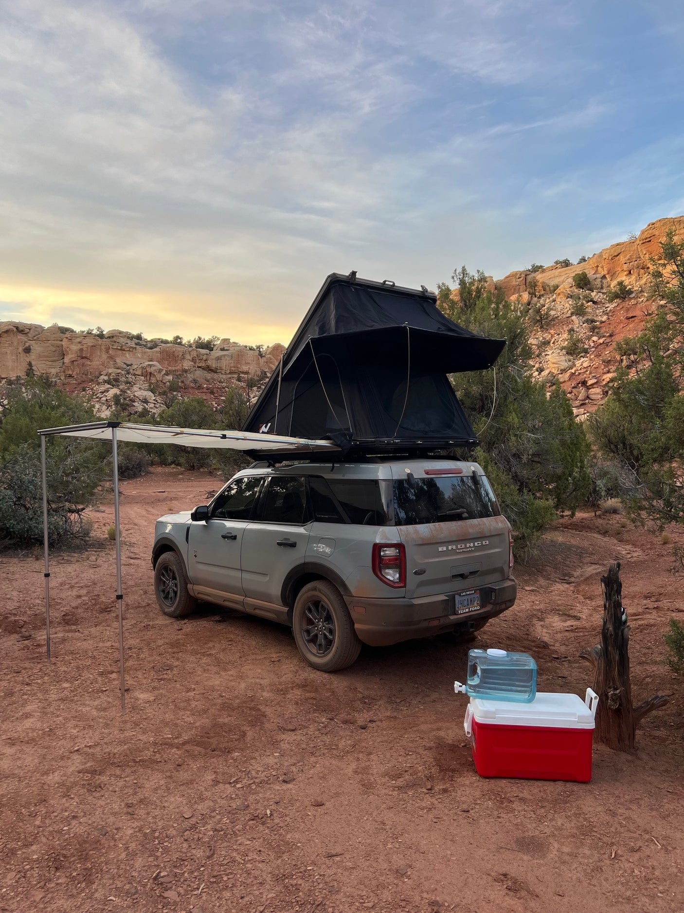 A grey Bronco Sport with a rooftop tent & awning, perfect for an RV rental overlanding adventure in red rock country.
