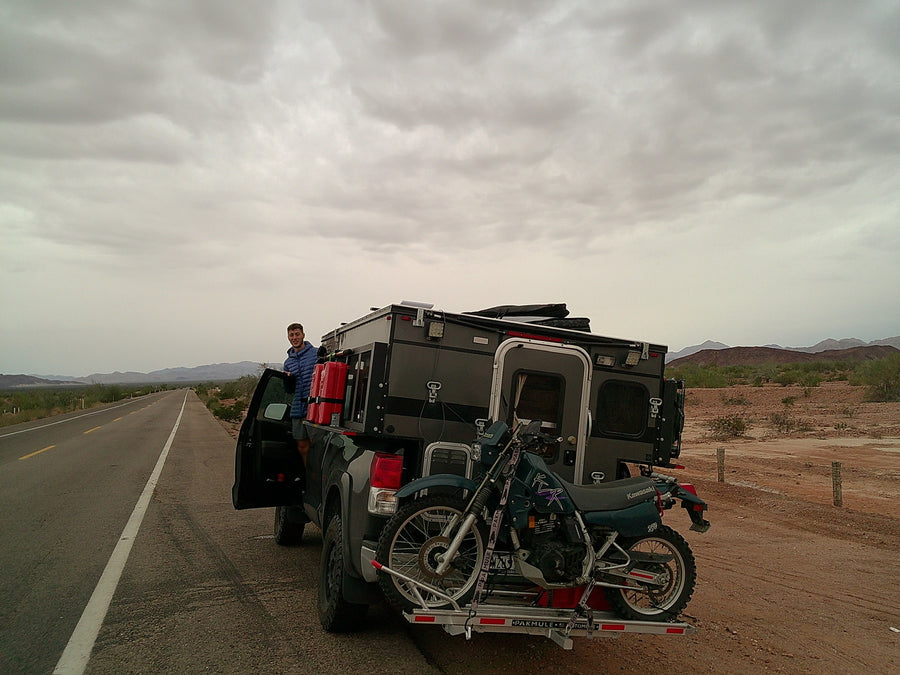 with a towed car.|Black truck with a truck camper & motorcycle on I-20 West