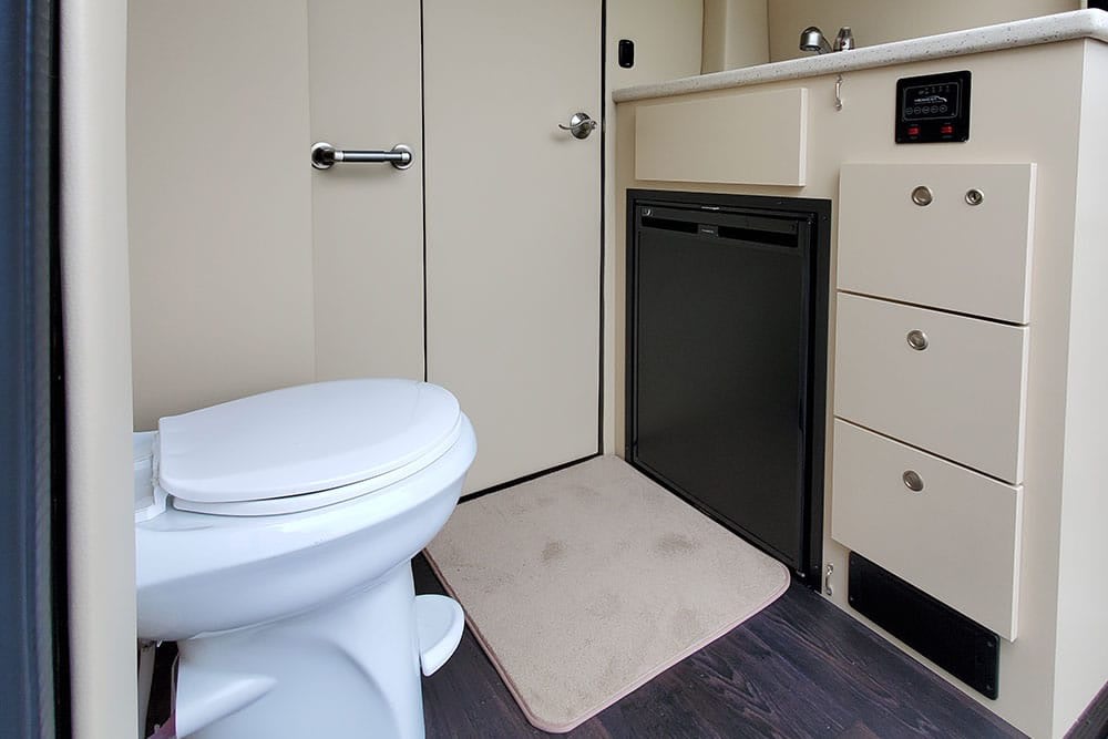and custom amenities for premium travel comfort.|Luxurious RV rental interior with plush cream captain's chairs