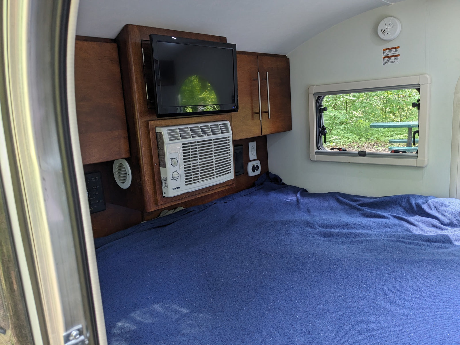 perfect for keeping food cold while camping.|An rv rental teardrop camper's open rear hatch reveals a compact kitchen with sink
