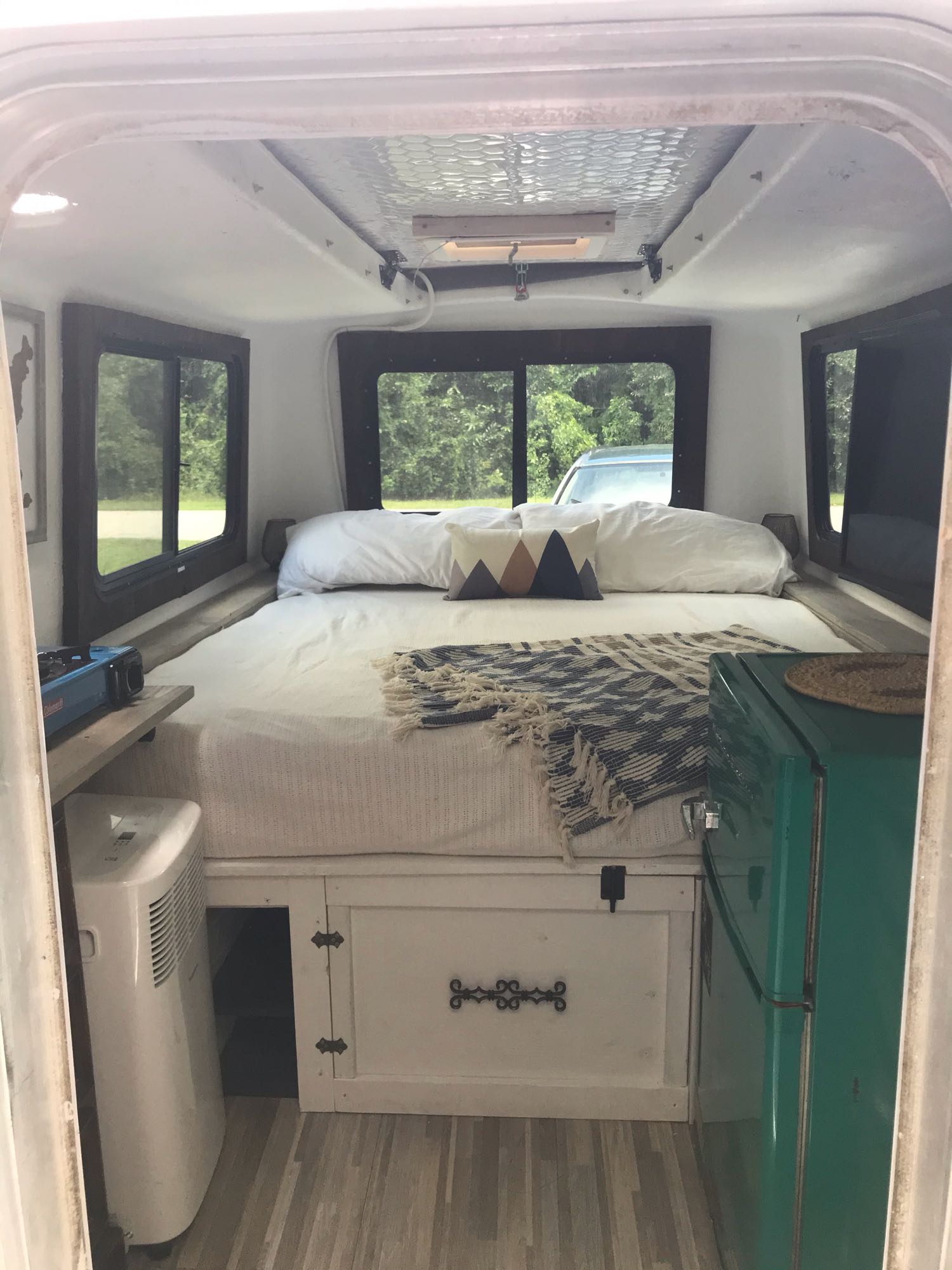 parked in a driveway. Great for an RV rental adventure!|Enjoying an rv rental at a scenic wooded campsite. White/blue trailer