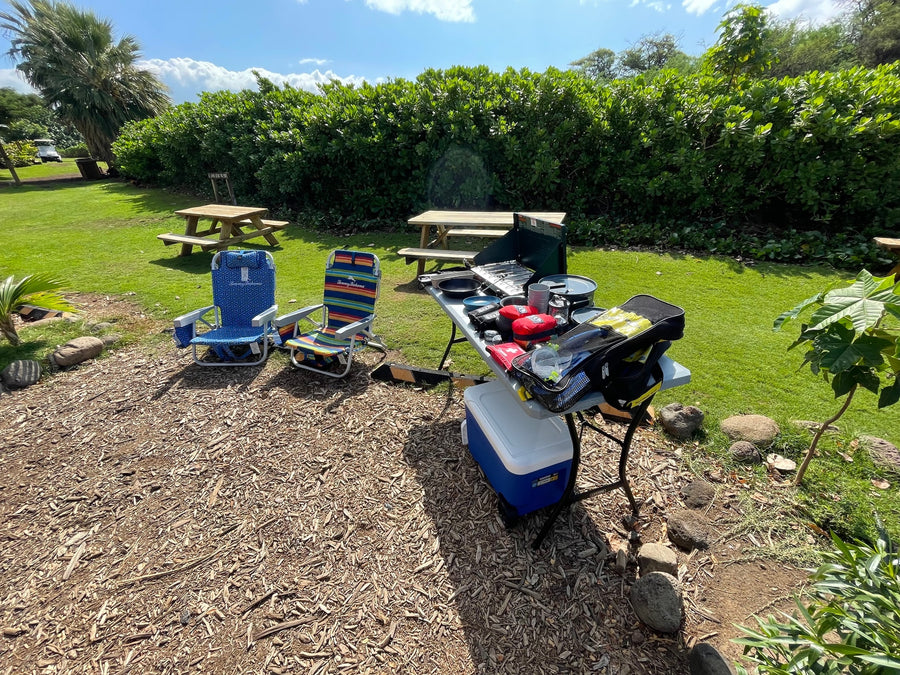 RV rental day! Outdoor kitchen setup with stove, cooler, chairs, & snorkel gear on wood chips for outdoor fun.