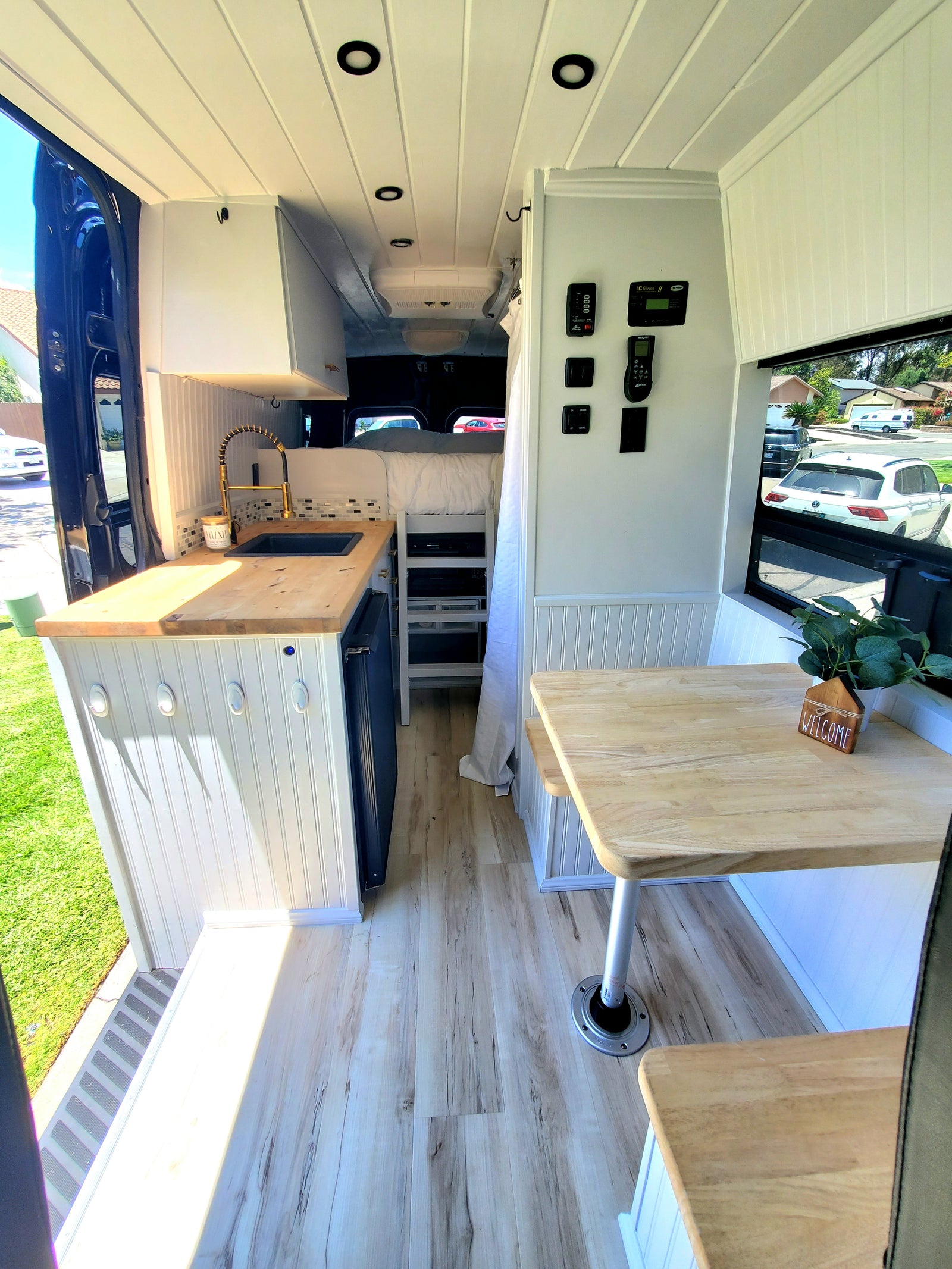 Cozy RV rental interior with modern kitchen, dinette, and sleeping area. Enjoy comfortable mobile living in this converted van.