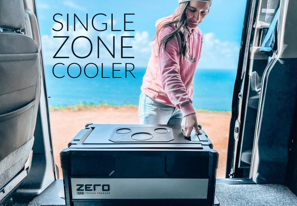 Perfect for your RV rental: a single-zone cooler for coastal adventures. A woman handles an ARB fridge in a van.