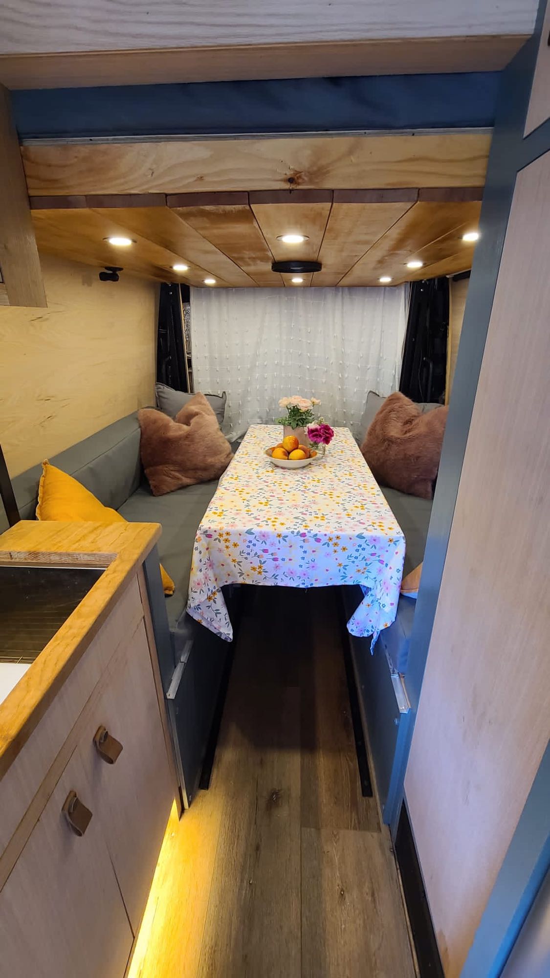 and cozy dining space.|Cozy RV rental interior: a dining area with floral tablecloth — photo 6