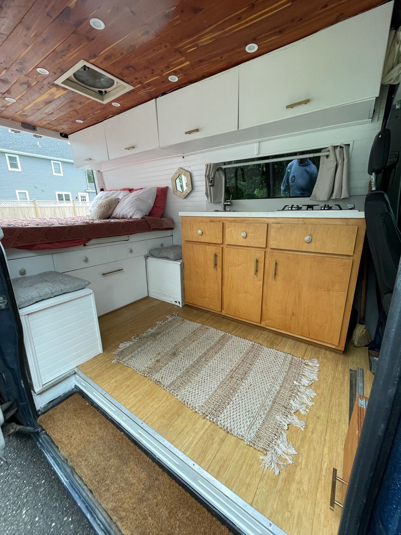 This RV rental's well-designed interior features a wooden ceiling, full kitchen, bed, and smart storage solutions. — photo 1