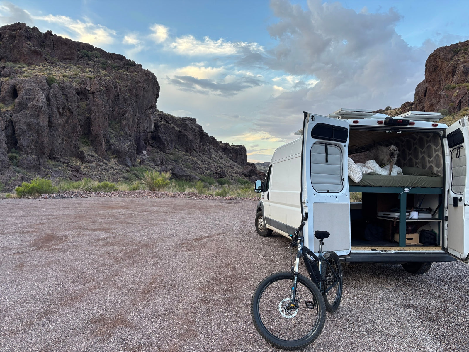 Adventure-ready RV rental setup with a dog, bike, and mountain views. Perfect for nature travel!