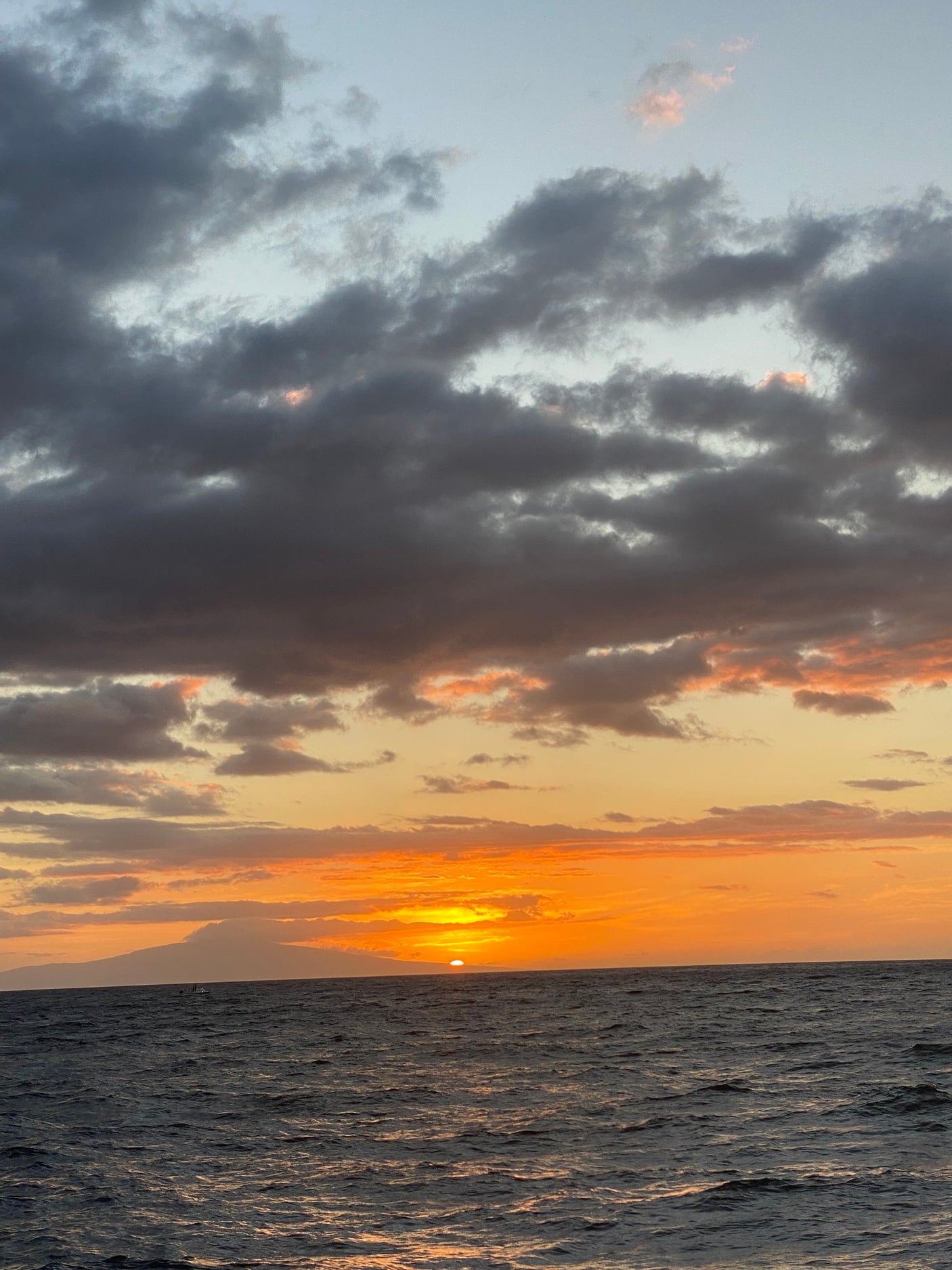 Golden sunset over calm ocean waves & clouds. A perfect end to an RV rental day.