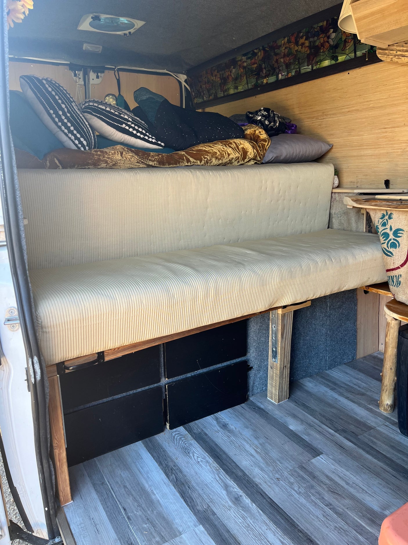 Step inside this cozy RV rental camper van! Features a corduroy bench bed, ample under-bed storage, and wood-paneled walls.