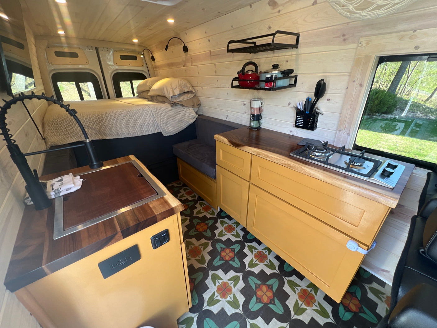 ready for adventure. Ideal for an RV rental getaway.|White Mercedes Sprinter camper van for your next RV rental adventure. Equipped with awning & bike rack.|Spacious RV rental interior featuring wood paneling