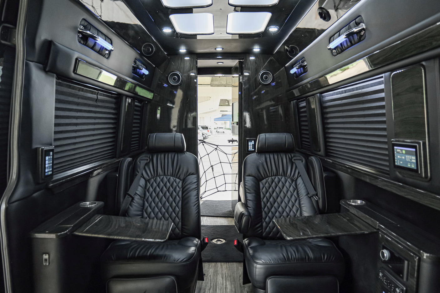 Plush black leather seating and modern amenities fill this spacious rv rental interior, ideal for travel comfort.