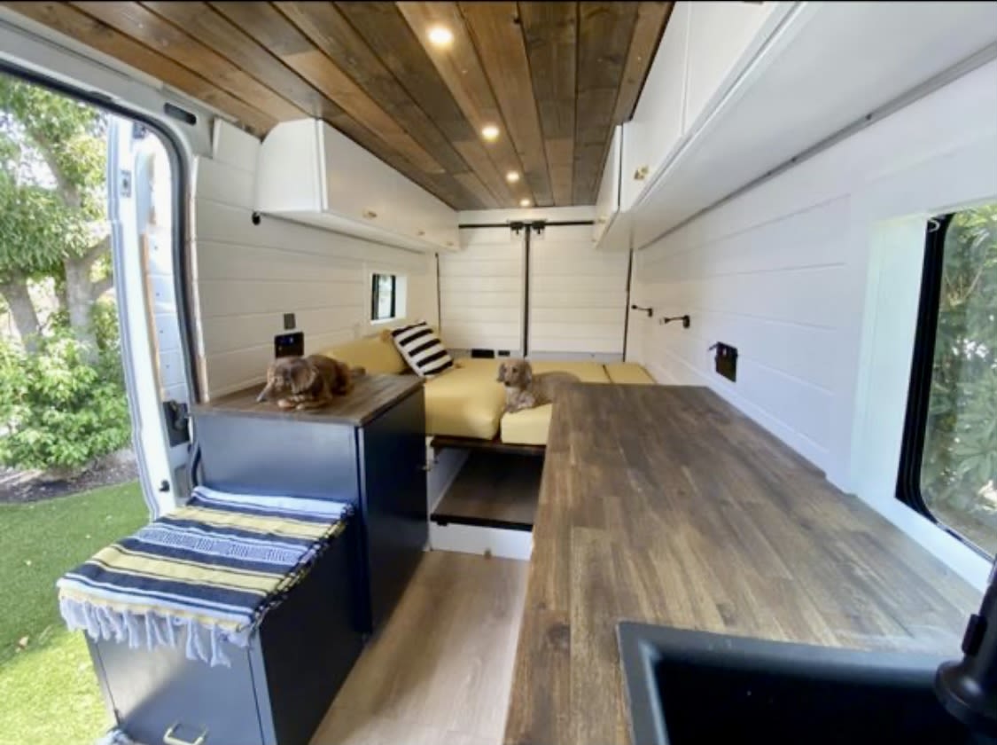 with a wooden ceiling. Perfect for van life!|An RV rental travels a scenic road through a stunning canyon. Towering