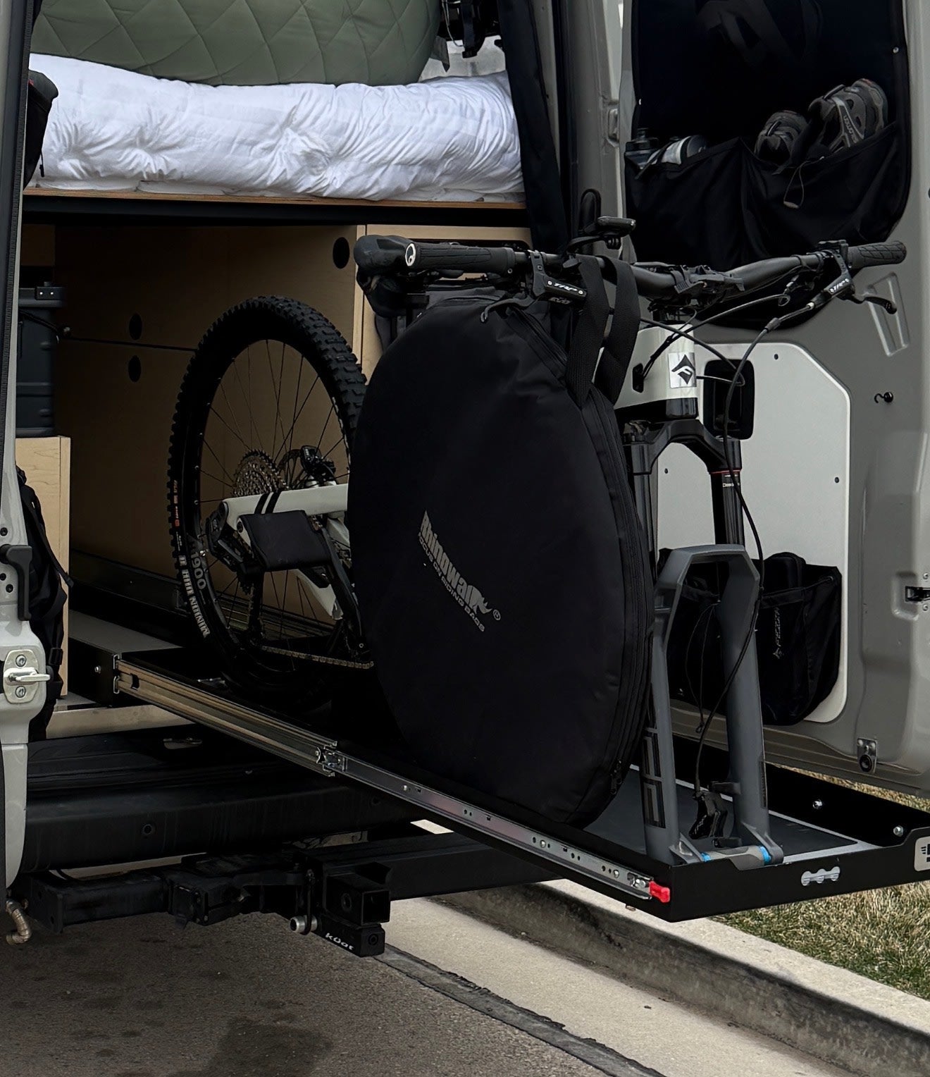 RV rental: Mountain bike stored securely on a rear pull-out tray in this camper van, ready for your next adventure.