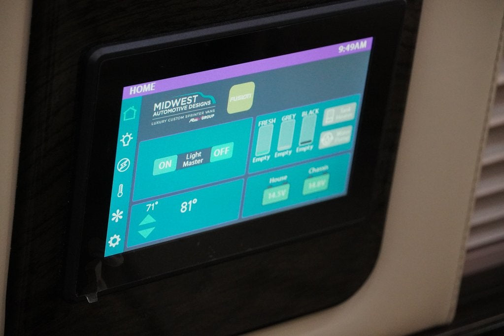 RV rental interior: A digital control panel shows 9:49 AM, lights, temperature (71°/81°), empty tanks, and 14.5V battery levels.