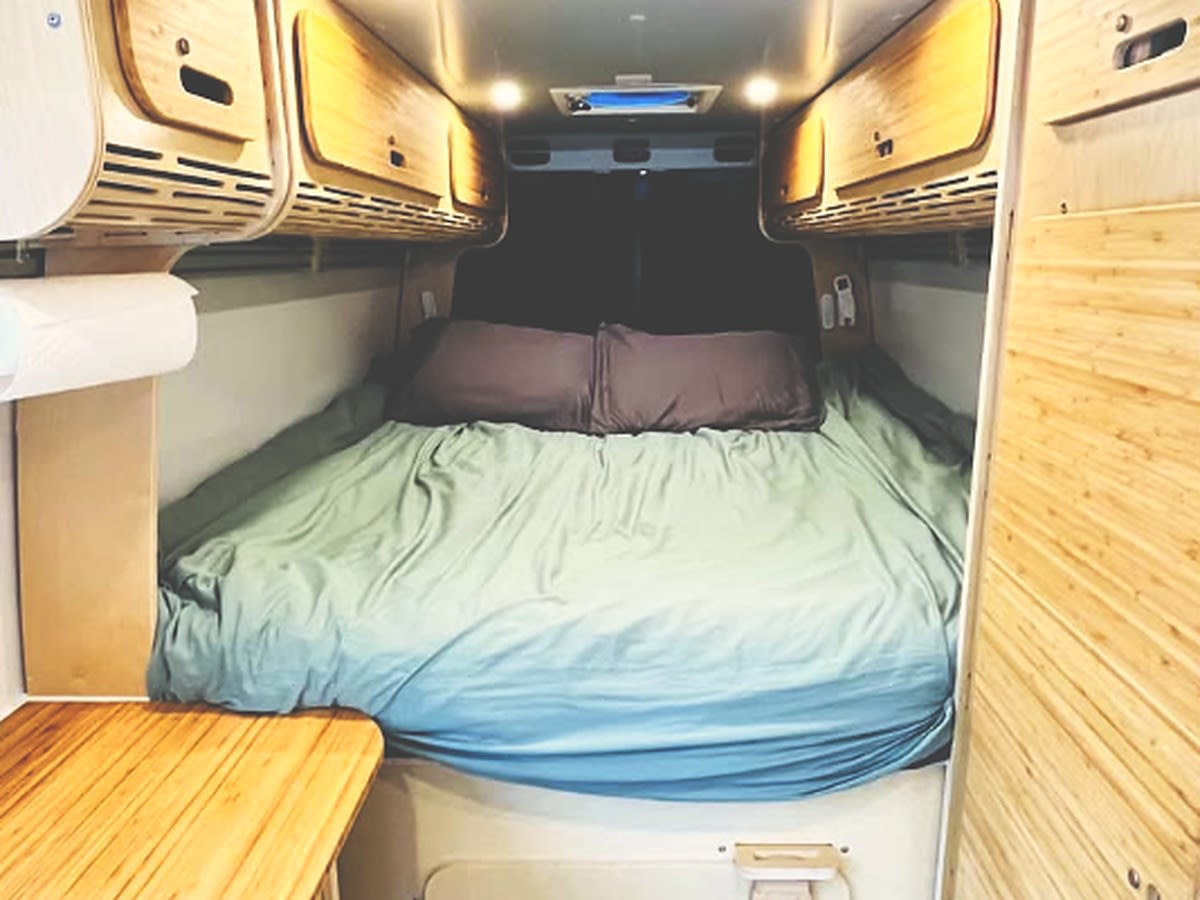 parked in a snowy forest. Ready for winter adventure!|Explore this modern RV rental campervan interior with a compact kitchen — photo 9