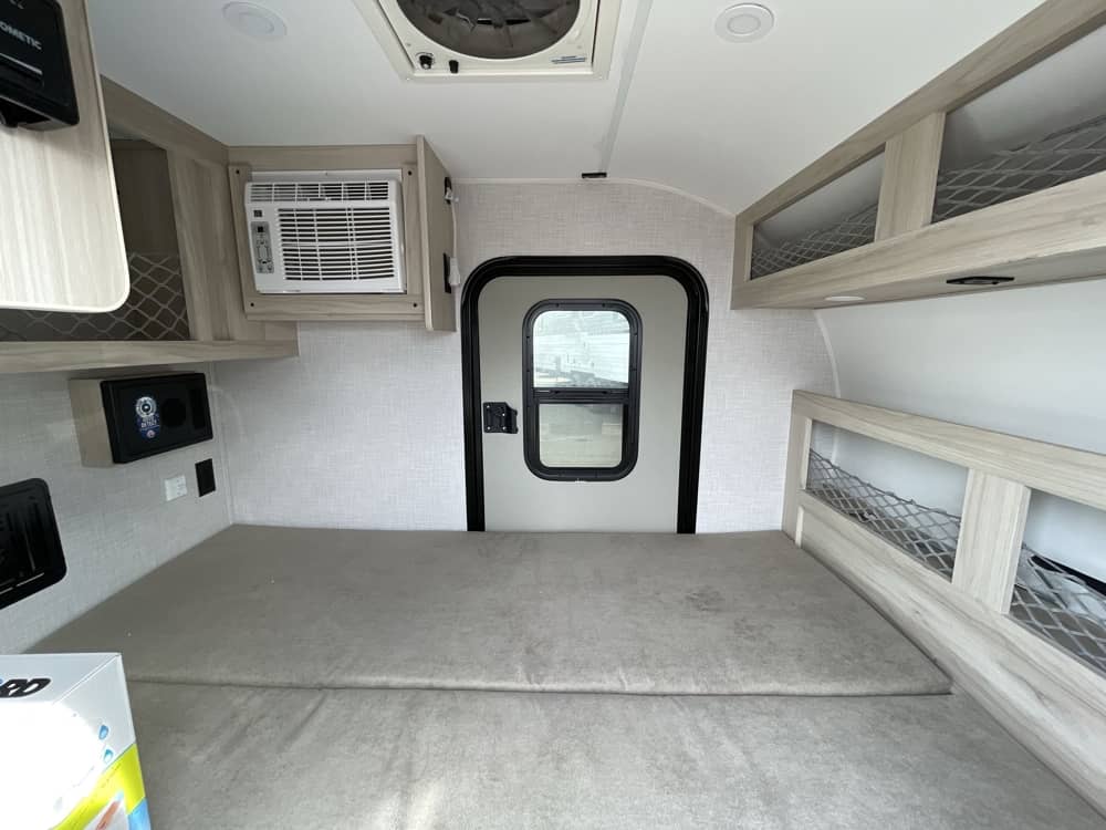 parked on a gravel lot.|Explore in this compact "Drifter" off-road travel trailer