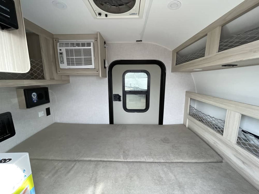 parked on a gravel lot.|Explore in this compact "Drifter" off-road travel trailer