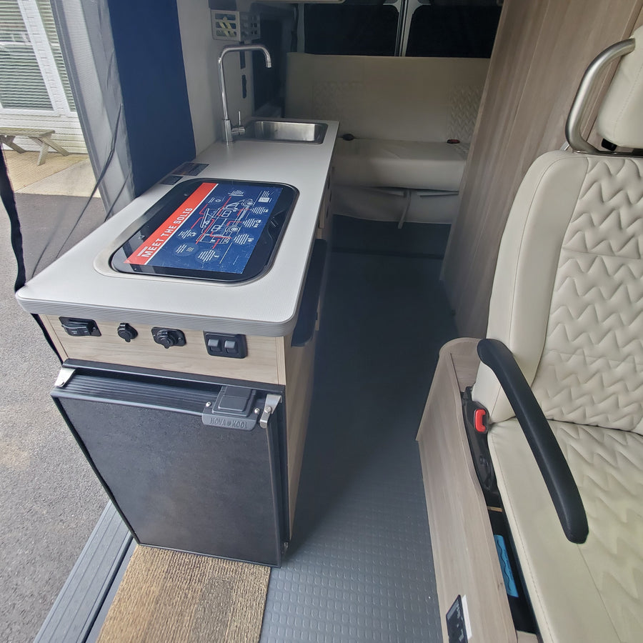parked outdoors with its side door open for adventure.|Spacious RV rental van interior showcasing dashboard