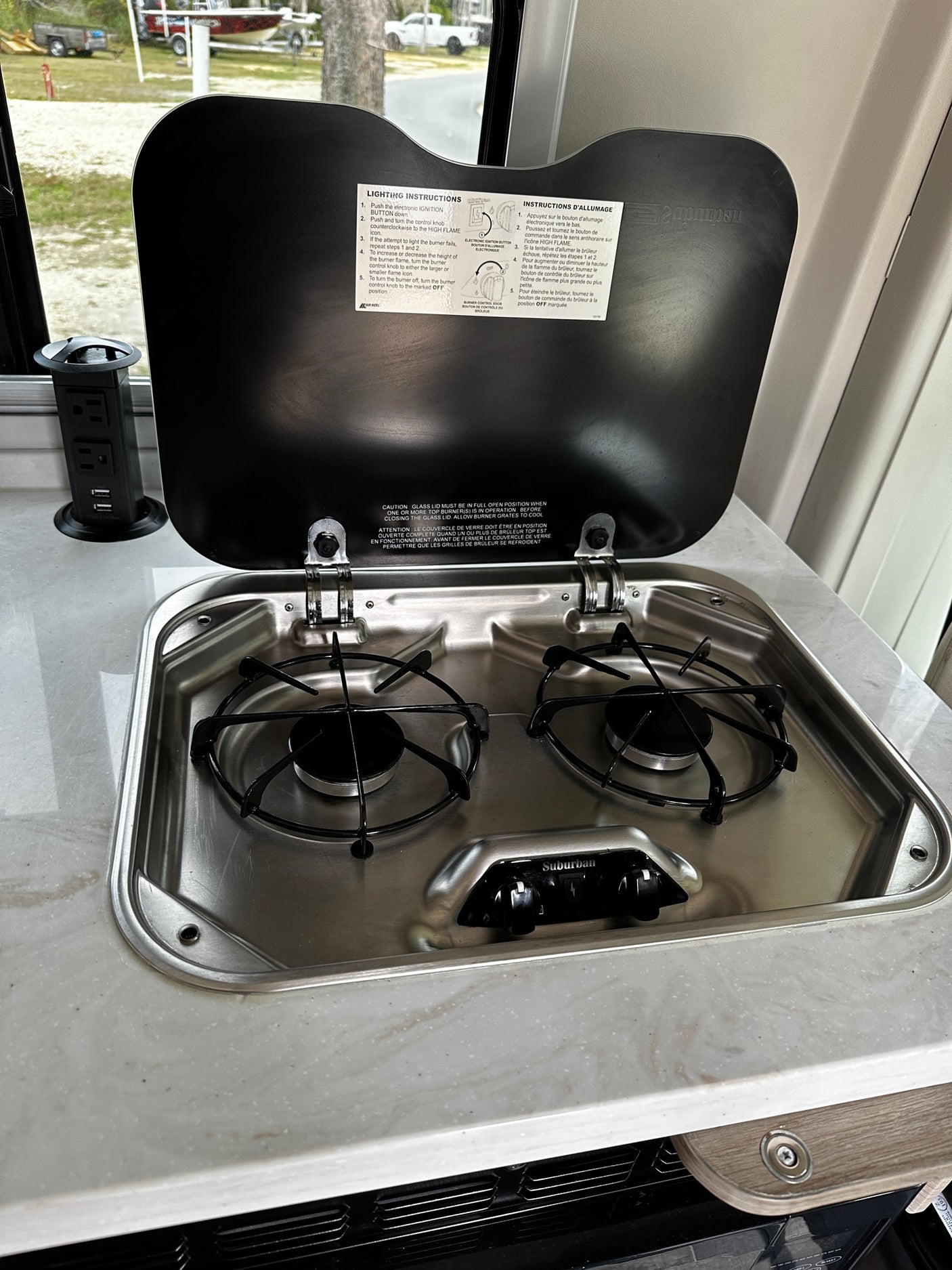 This rv rental features a compact stainless steel two-burner stove, ideal for cooking meals in your camper kitchen.