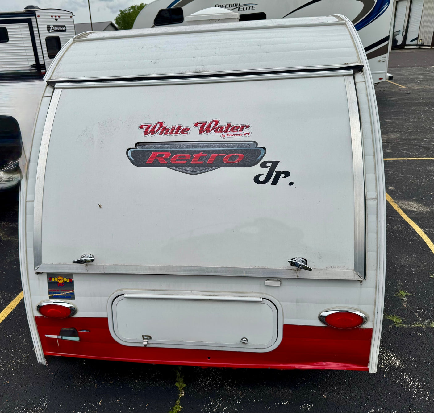 and a ceiling fan.|An rv rental's interior shows a cozy bed