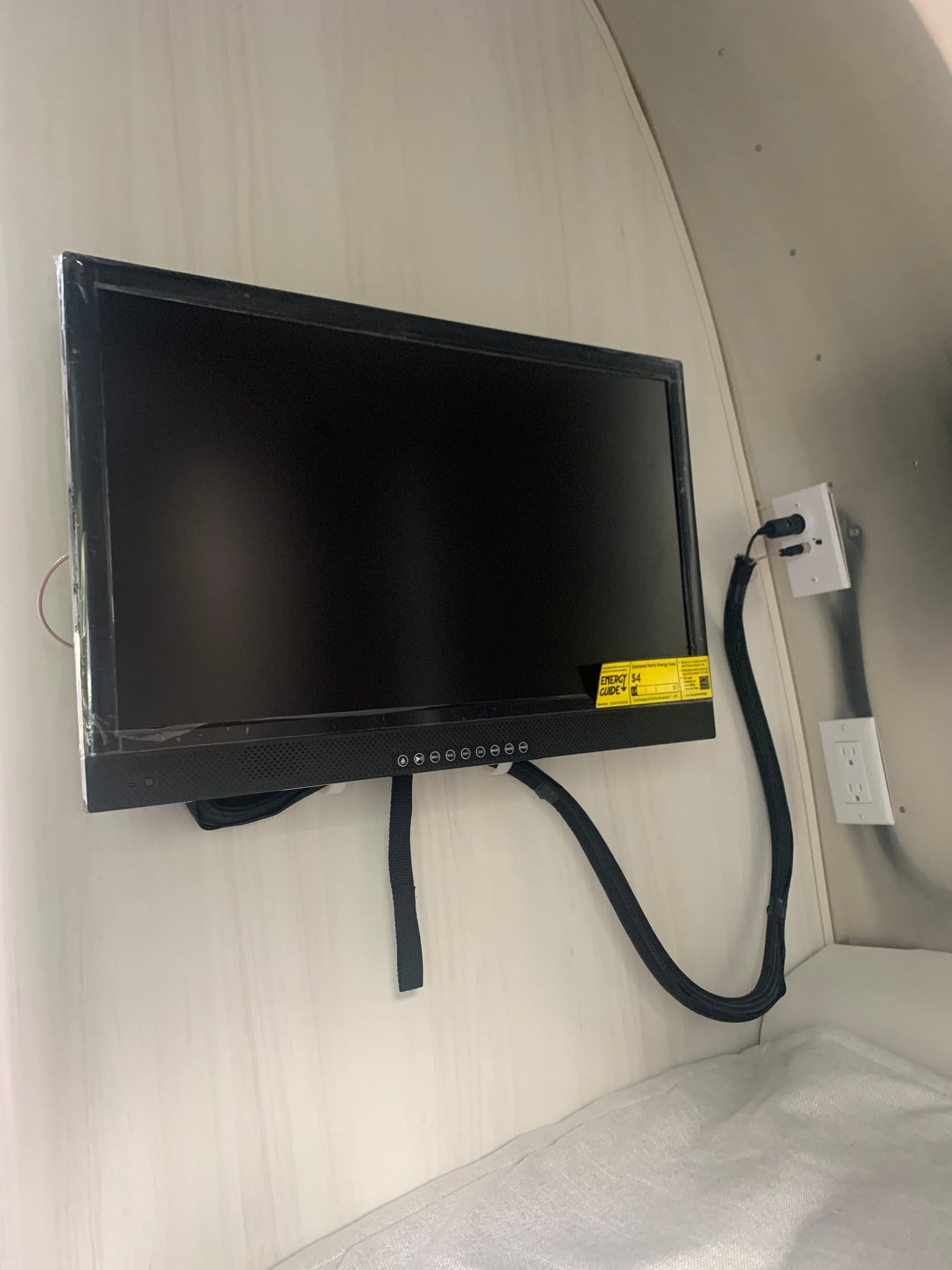 Wall-mounted TV and power outlets inside an RV rental, providing entertainment and convenience in a compact space. — photo 5